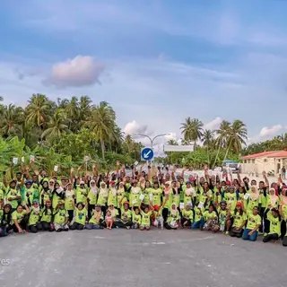 Large group of riders in lime hi-vis shirts on an island road